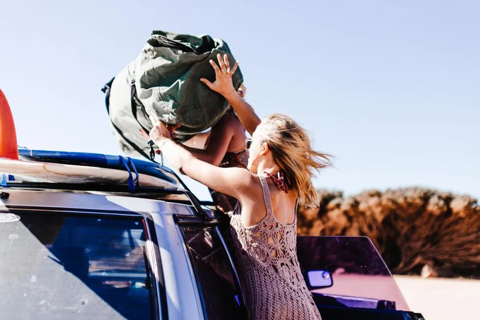 Loading a travel bag onto a car for a road trip